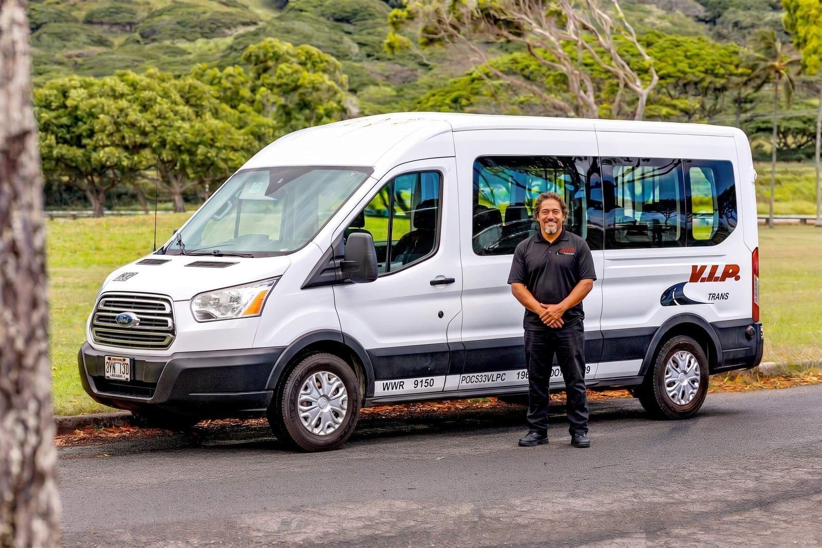 A VIP Trans Maui shuttle driver welcoming passengers beside the shuttle
